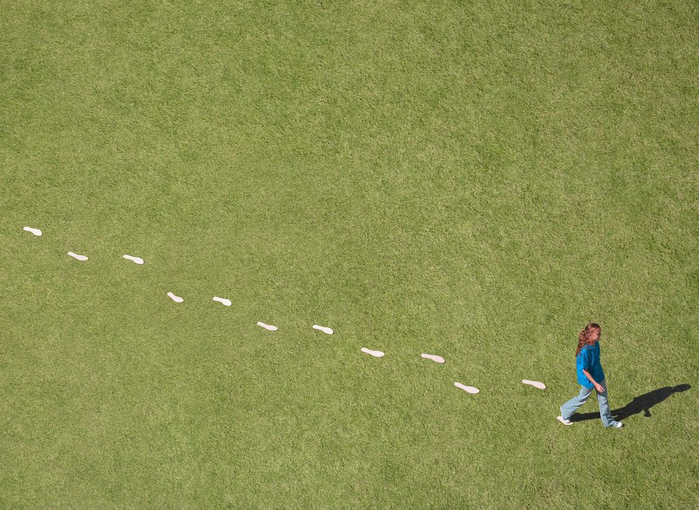 Girl walking with visible footprints behind her