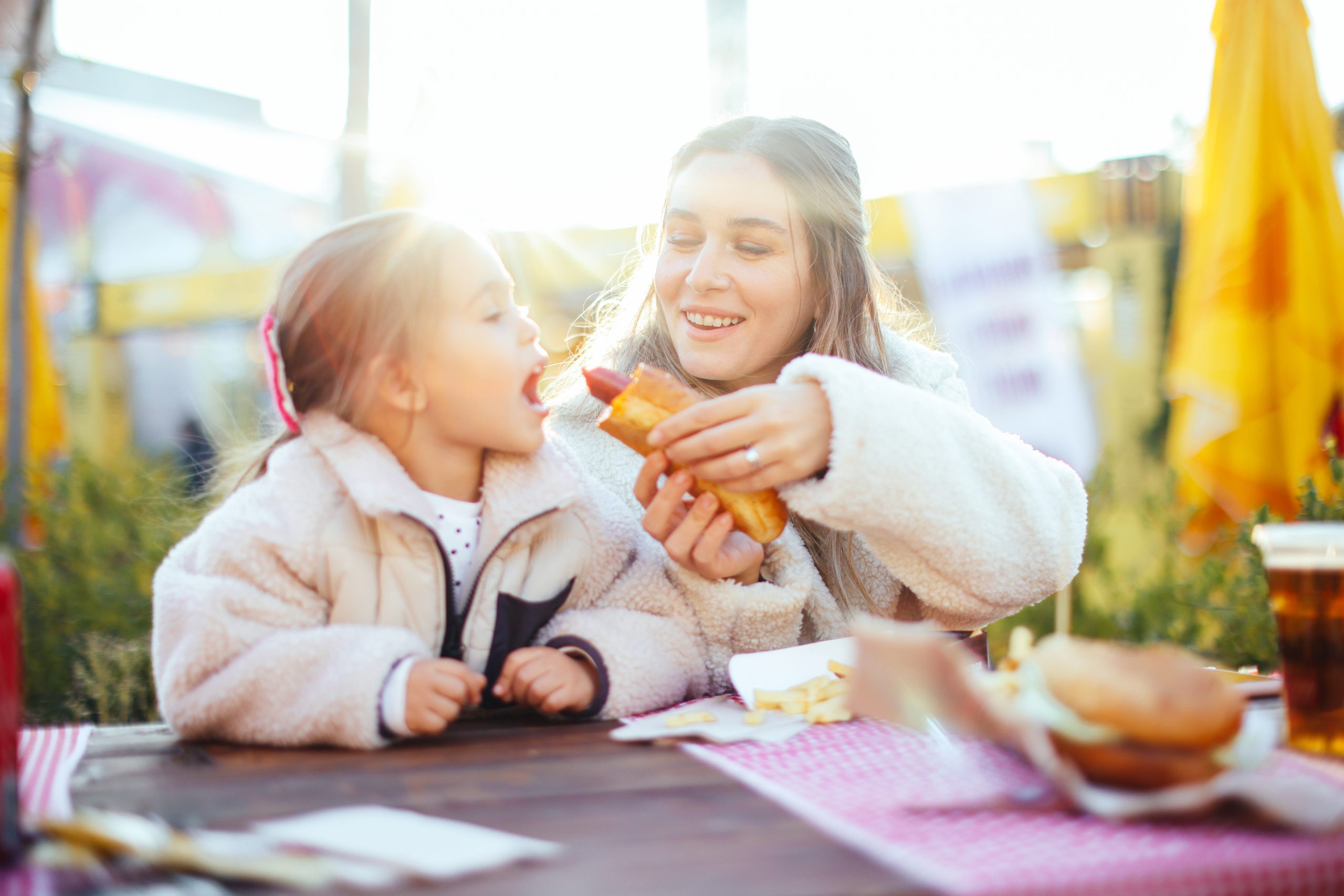 Mother and daughter eating hot dog