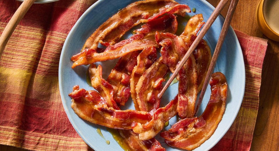 Miso brown sugar-glazed thick cut bacon on blue plate with chopsticks