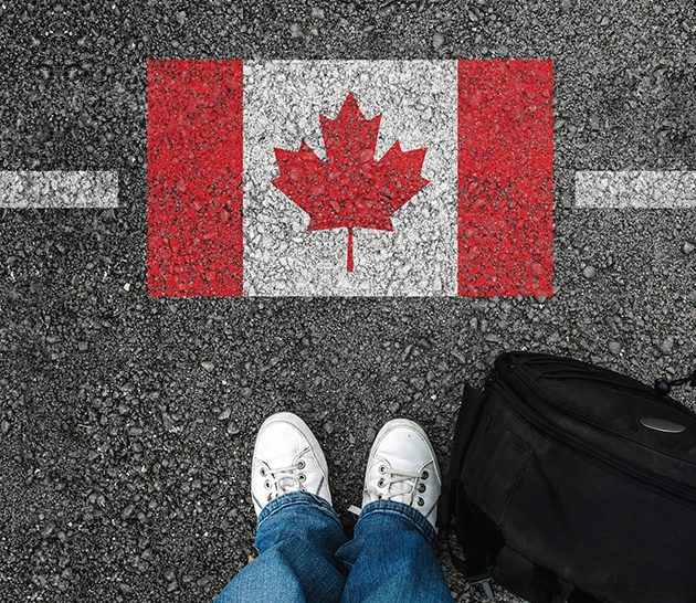 A man with a shoes is standing next to flag of Canada stock photo